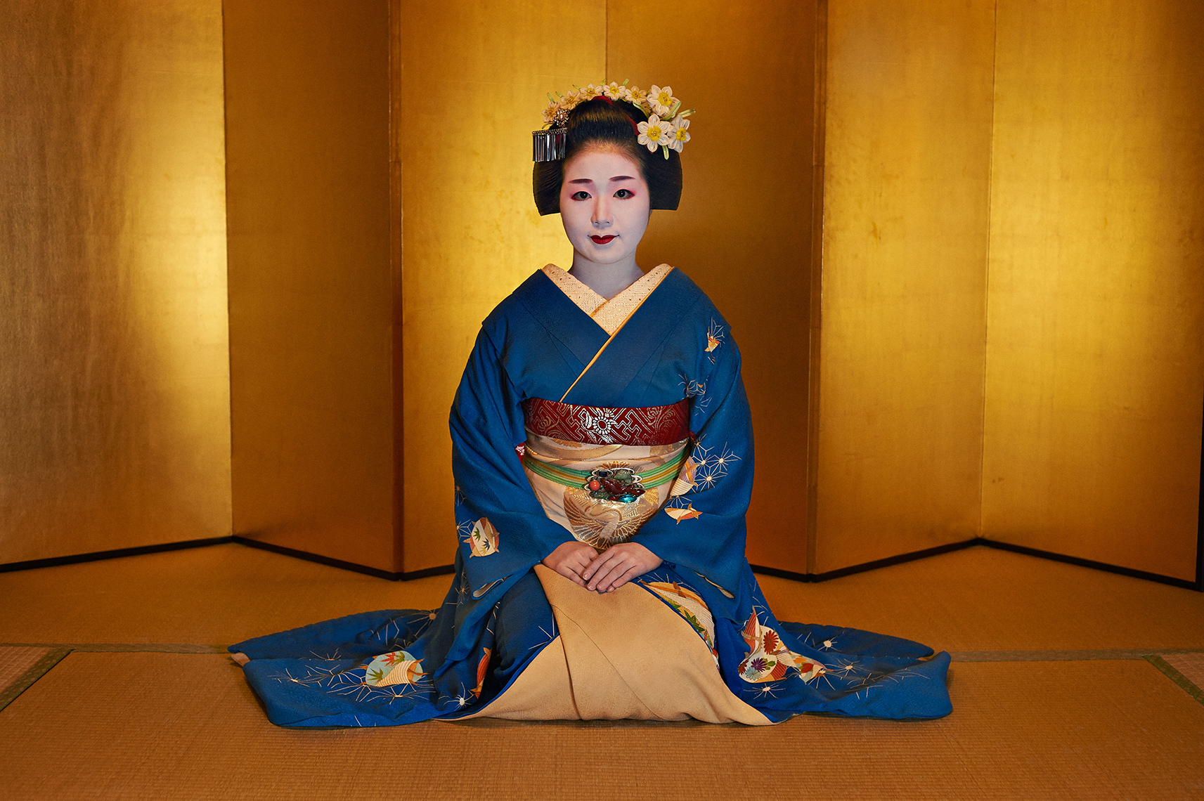 A maiko (trainee geisha) in the entertaining room of a geisha house in the historic Gion district of Kyoto, Japan