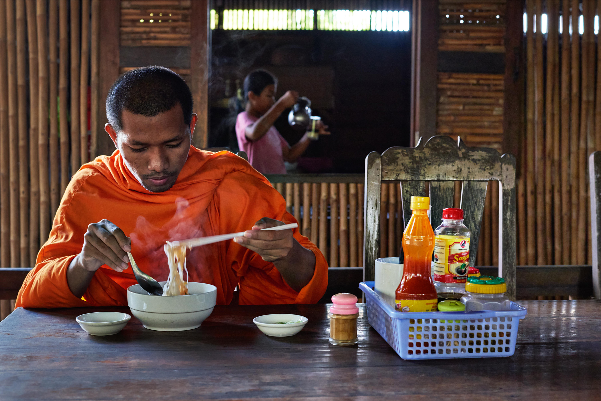 Monk eating breakfast noodle dish of kuy teav | Cambodia | People Portraits Photography